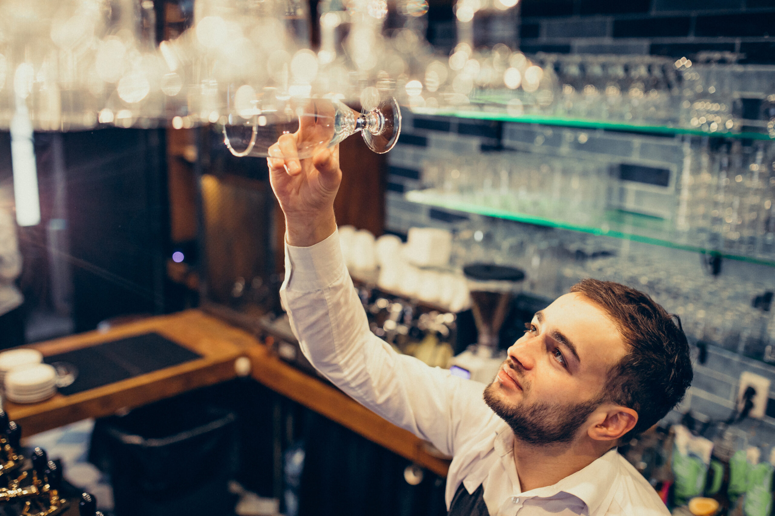 Handsome bartender making drinking and cocktails at a counter